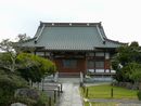 妙日寺の境内に作庭された植栽と参道の石畳越に見える本堂